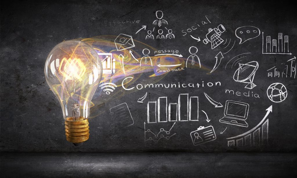 Glass glowing light bulb and business sketched ideas